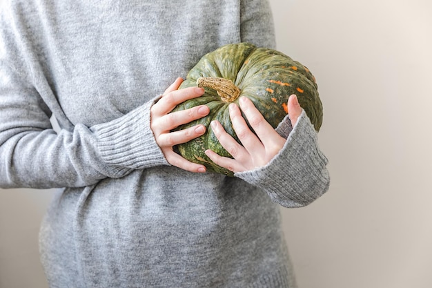 Fundo outonal mão de mulher irreconhecível segurando nas mãos outono outono abóbora isolada no fundo branco mudança de estações alimentos orgânicos maduros festa de halloween dia de ação de graças