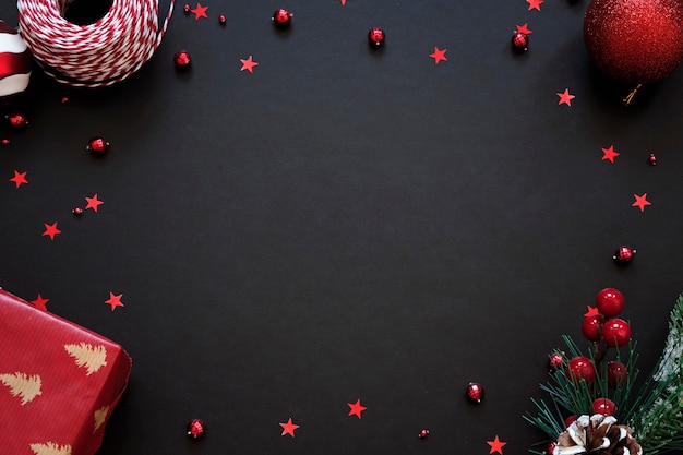 Fundo preto festivo com decoração vermelha. Cartão de Natal com lugar para texto