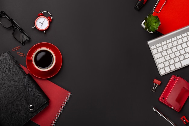 Fundo preto vermelho copo de café notepad despertador flor diário pontuação teclado na mesa