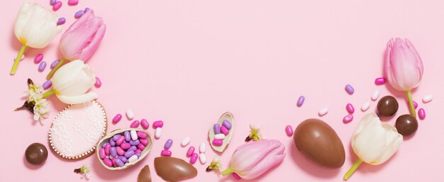 Fundo rosa da Páscoa com ovos e flores