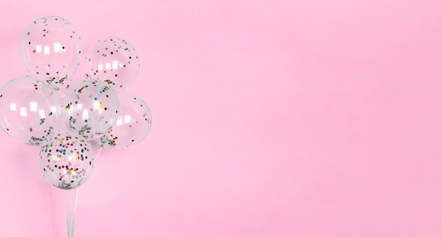 Fundo rosa festivo com balões com confete colorido brilhante bandeira brilha decoração de papel de parede