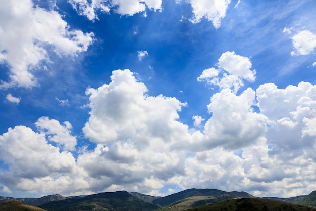 Fundo rural cênico com céu azul e nuvens fofas brancas