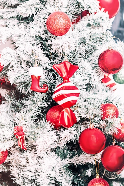 Foto fundo sazonal com brinquedo vermelho de natal na árvore. conceito de inverno. foco seletivo.