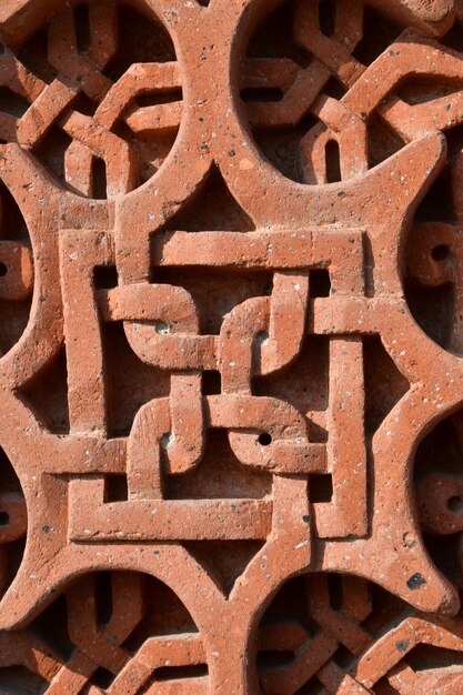 Fundo, textura de pedra. Escultura em pedra. Pedra vermelha com um padrão.