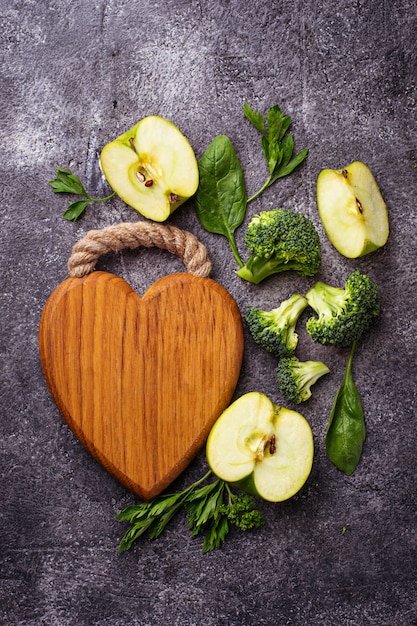 Fundo verde comida com placa de madeira em forma de coração