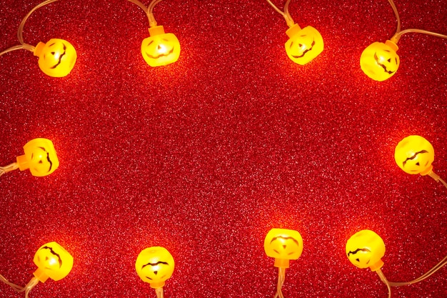 Fundo vermelho brilhante com luzes de abóbora de halloween com espaço de cópia