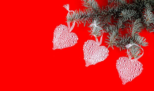 Fundo vermelho de natal com rtee branchew e corações de natal, cópia espaço