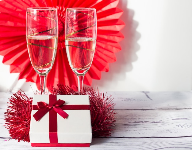 Foto fundo vermelho e branco do dia dos namorados com uma caixa e taças de champanhe