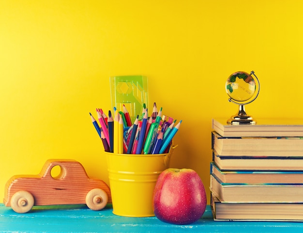 Foto fundo volta para a escola com lápis de papelaria de crianças, livros, apple, globo de vidro