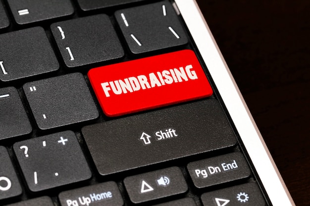 Fundraising auf rotem Enter-Button auf schwarzer Tastatur.