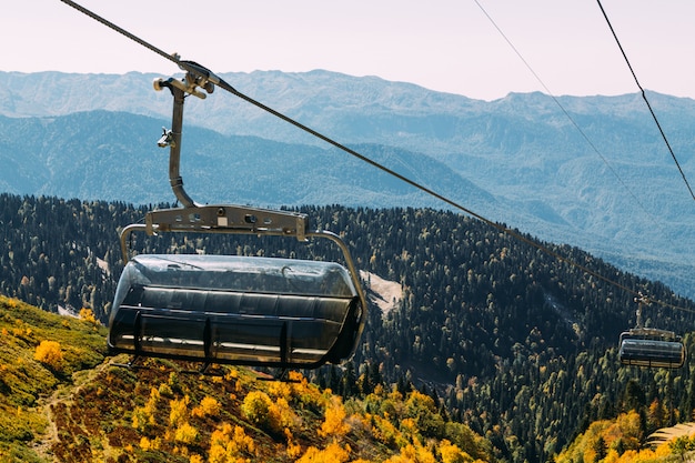 Funicular alto en las montañas sobre el bosque de otoño