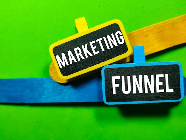 Foto funil de marketing de conceito de negócios escrito em placa de madeira colorida com palitos de sorvete coloridos em fundo verde