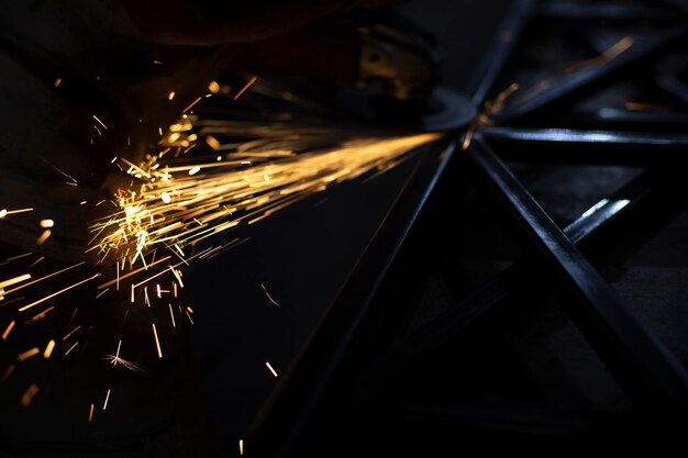 Foto funken von stahl-metall-säge-lichtern in der dunkelheit arbeit in der garage sägen werkstück