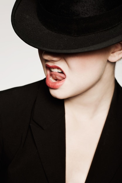 Funky Style Eine ausdrucksstarke junge Frau mit roten Lippen und Hut