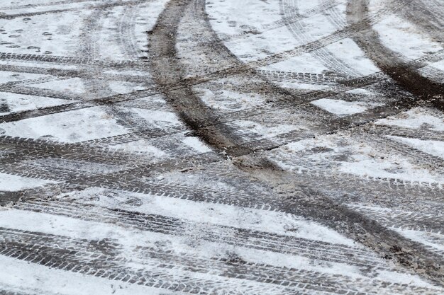 Furchen auf weißen Schneespuren von den Rädern der Autos