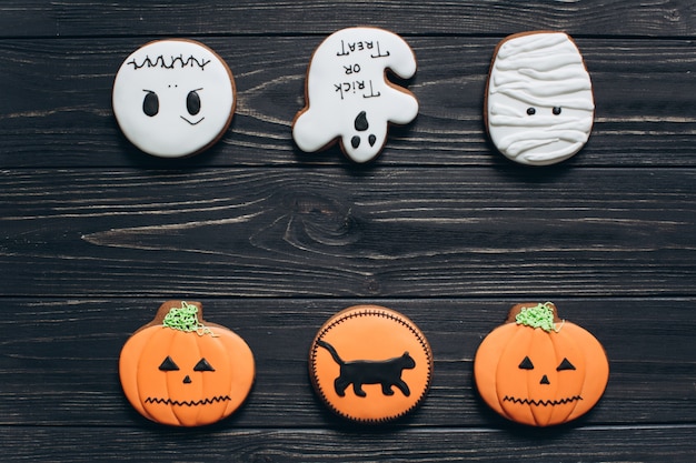 Foto furchtsame lebkuchen für halloween auf einem schwarzen hölzernen hintergrund.