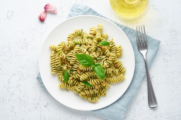 Fusili-Teigwaren mit Basilikum Pesto und Kräutern, italienische Küche, grauer Stein, Draufsicht