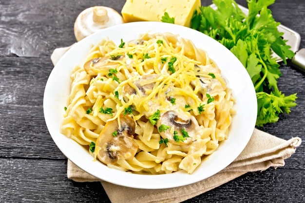 Fusilli con champiñones en placa en tablero negro