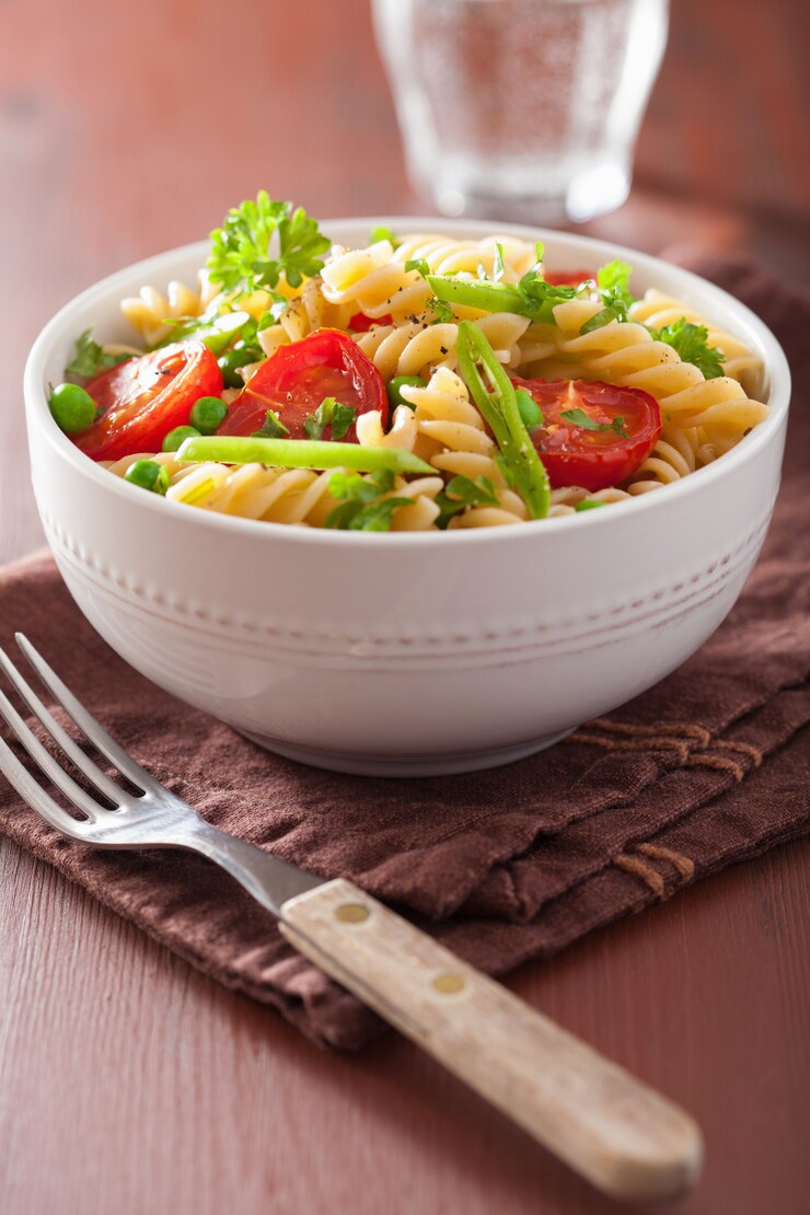 Foto fusilli de massa vegetariana com ervas de ervilhas de tomate