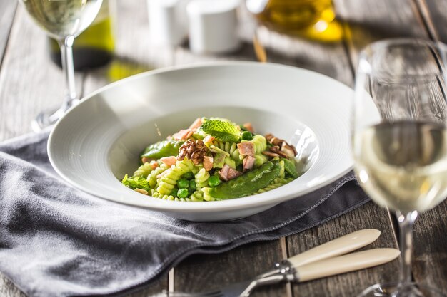 Fusilli-Nudeln mit grünen Erbsen-Schinken-Walnüssen mit Weißwein. italienische oder mediterrane Küche.