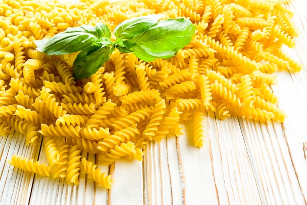 Fusilli Nudeln und Basilikumblatt auf dem Tisch