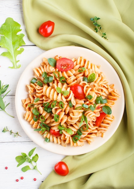 Fusilli pasta con salsa de tomate, tomates cherry, lechuga y hierbas