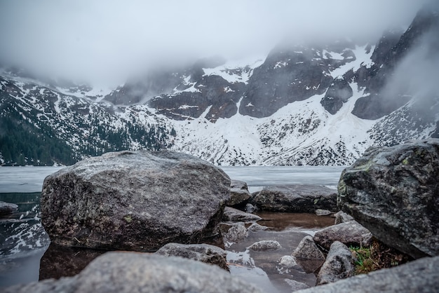 Fusión de hielo de un lago de montaña en los picos nublados de las montañas en Polonia