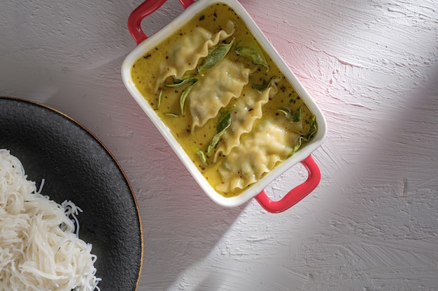 Fusionsfutter aus grünem Curry mit Knödeln. Grünes Curry (Kaeng kheiyw hwan) mit thailändischem Essen für gedämpften Reis oder Reisnudeln. Sehr beliebtes thailändisches Essen, Gyozas-Suppe.