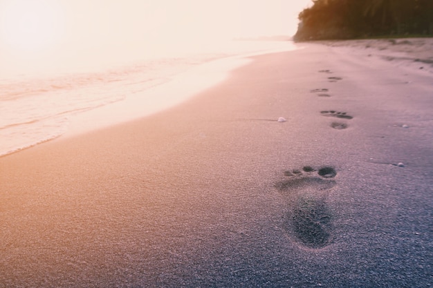 Fußabdruck am Strand auf Sonnenaufgang Meer Hintergrund mit Vintage-Filter