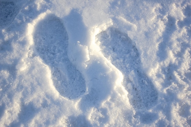 Fußabdrücke im Schnee von Stiefeln Ein Fußabdruck in einem Schnee von einer Person Füße