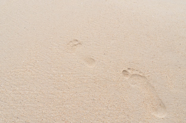 Fußabdrücke von Menschen am Strand