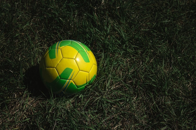 Fußball auf dem Rasen auf dem Feld Fußballsport und Erholung Gelber und grüner Lederball