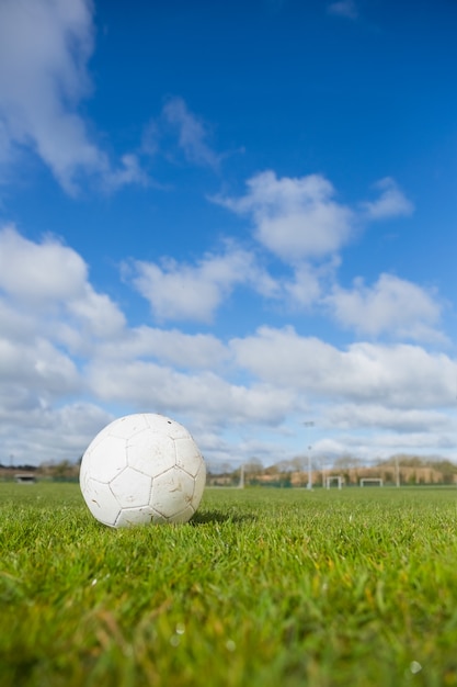 Fußball auf dem Rasen unter blauem Himmel