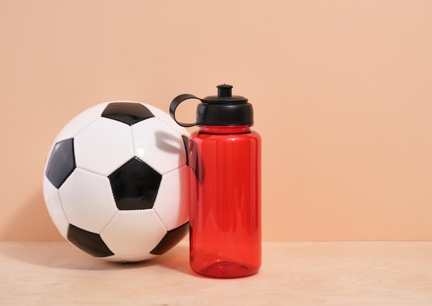 Fußball und roter Sportshaker für Wasser und andere Getränke Kopieren Sie Platz für Text