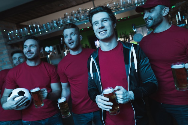 Fußballfans feiern und trinken Bier.