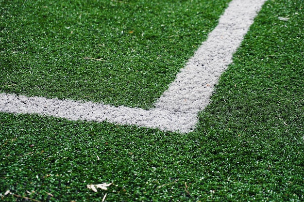 Fußballfeld mit grünem Gras. Die Ecke eines Fußballfeldes aus nächster Nähe