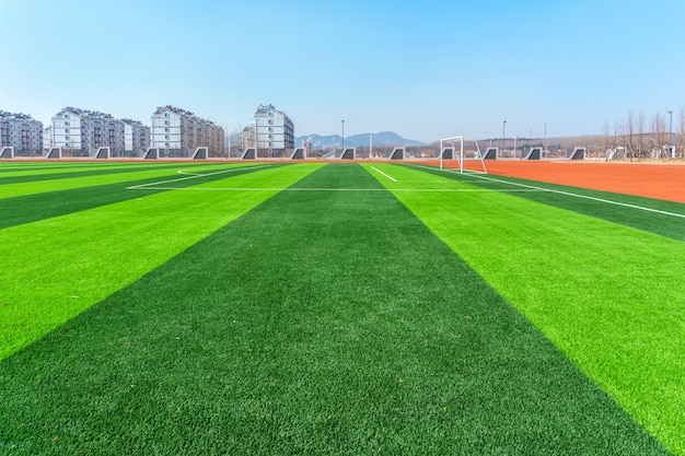 Fußballplatz und bewölkter Himmel. Grünes Feld.