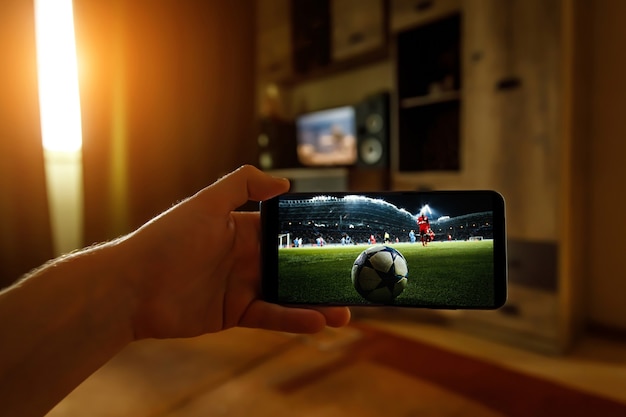 Fußballspiel zu Hause über das Smartphone anschauen. Übertragung von Fußball aus dem Stadion.