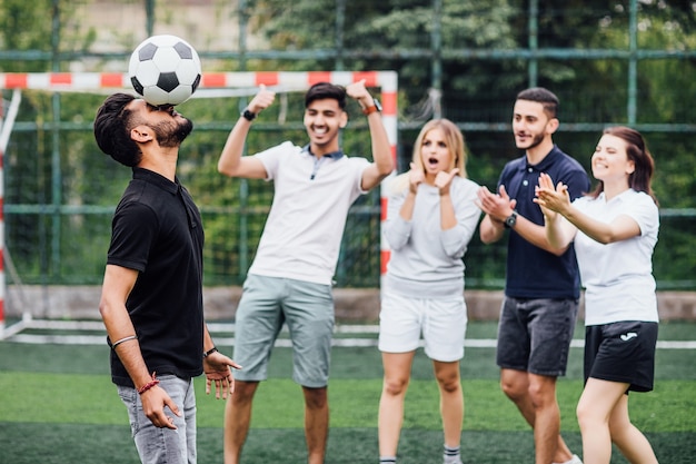 Fußballspieler, der mit Ball spielt und den Kopf schlägt