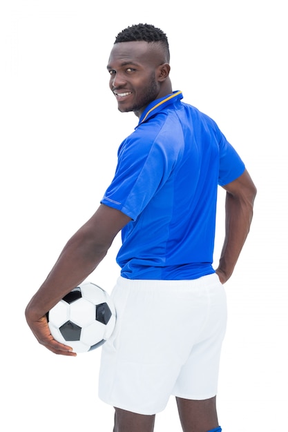 Fußballspieler in der blauen Stellung mit dem Ball