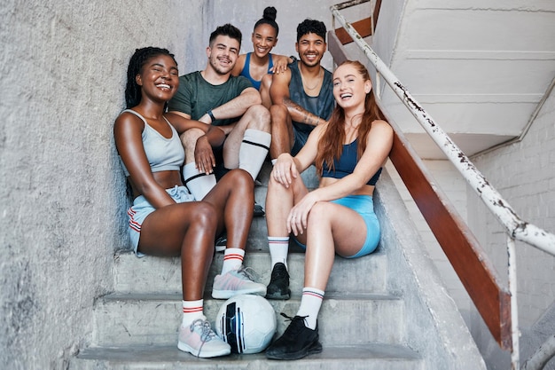 Foto fußballsport und ein team von freunden auf stufen nach dem fitnesstraining, die gemeinsam spaß und cardio-übungen haben vielfältige gesunde und glückliche athleten auf der treppe bereit für ein fußballspiel oder training