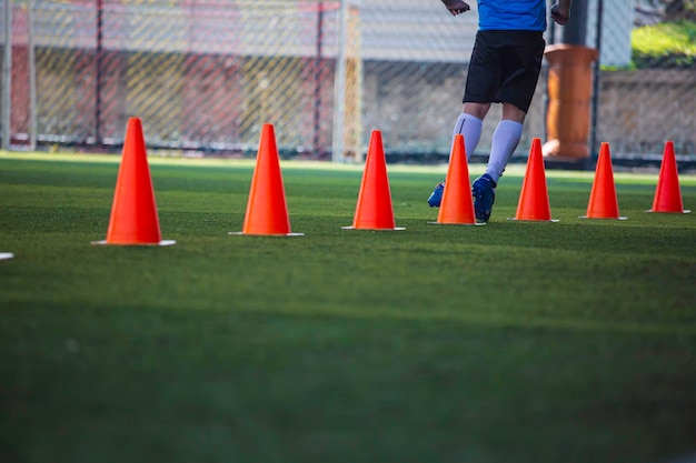 Fußballtaktik auf dem Rasenplatz mit Barriere zum Trainieren der Sprungfähigkeit von Kindern