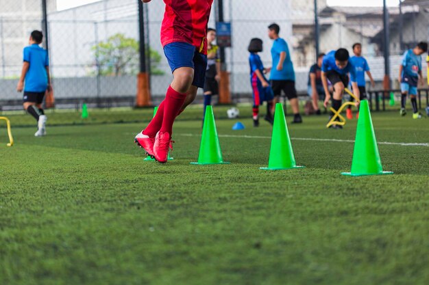 Fußballtaktik auf dem Rasenplatz mit Barriere zum Trainieren der Sprungfähigkeit von Kindern