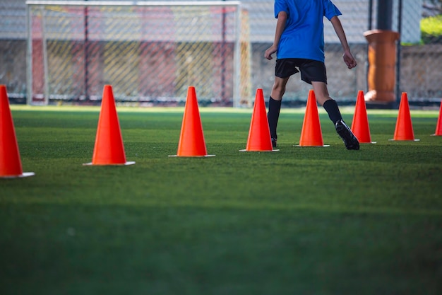 Fußballtaktiken auf Rasen mit Barriere zum Trainieren der Sprungfähigkeit von Kindern in der Fußballakademie