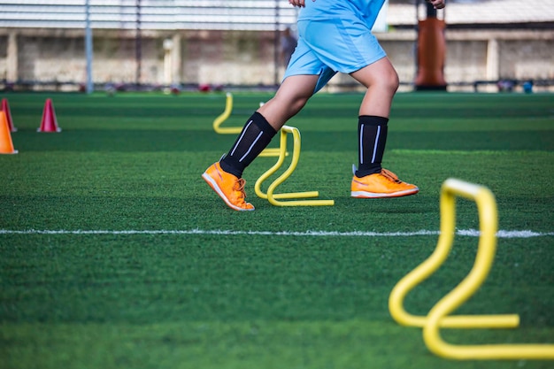 Fußballtaktiken auf Rasen mit Barriere zum Trainieren der Sprungfähigkeit von Kindern in der Fußballakademie