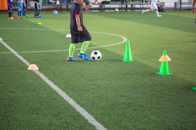 Fußballtaktiken auf Rasen mit Kegel für das Training von Thailand im Hintergrund Training von Kindern in der Fußballakademie