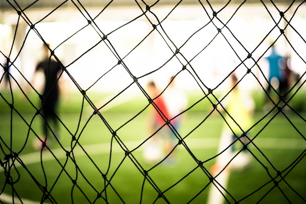 Fußballtrainingsnetzunschärfe auf Trainingsplatz mit Kindern