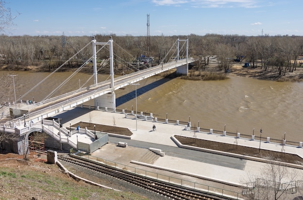 Fußgängerbrücke Damm und Fluss Ural im Frühjahr in Russland in der Stadt Orenburg