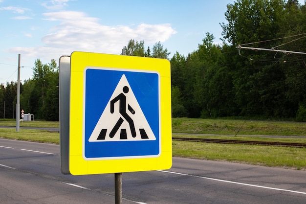 Fußgängerüberweg-Schild auf dem Hintergrund der Straße