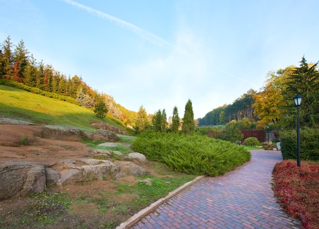 Fußgängerweg und Tannenbäume auf Hügel im schönen Herbststadtpark